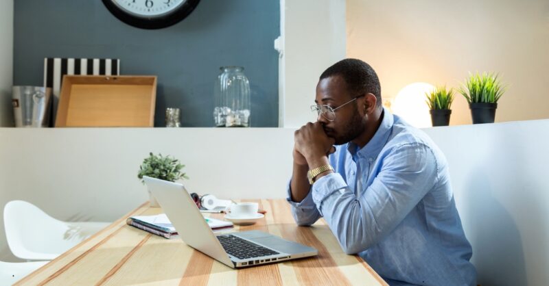 a man sitting at a table with a laptop