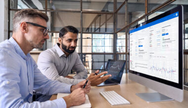 a group of men looking at a computer screen