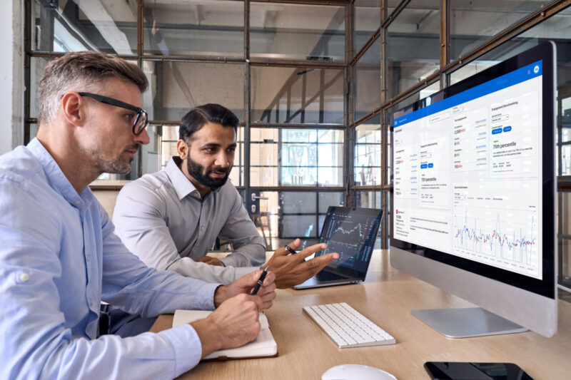 a group of men looking at a computer screen